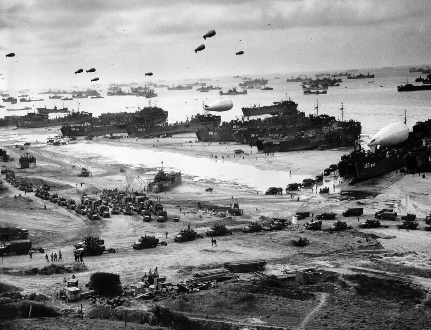 Landing ships putting cargo ashore on Omaha Beach at low tide during the early days of the Allied invasion. 